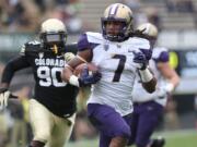 Washington running back Shaq Thompson, front, runs for a touchdown past Colorado defensive lineman De'Jon Wilson in the first quarter at Boulder, Colo., on Saturday, Nov. 1, 2014.