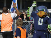 Blitz, the Seattle Seahawks NFL football mascot, gives a high five Monday at a community gathering in Darrington.