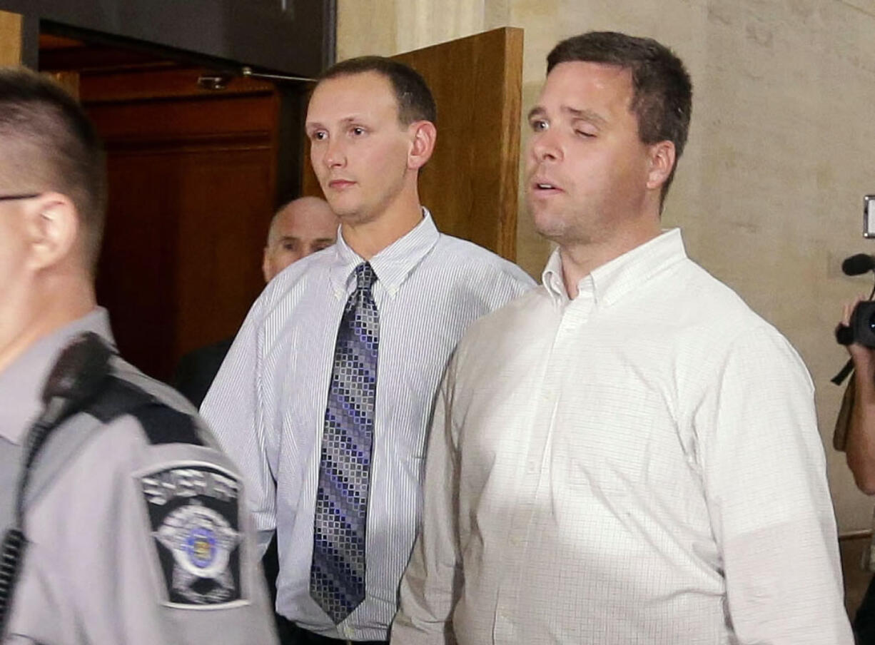 Former Milwaukee police officers Graham Kunisch, right,  and Bryan Norberg, who were shot and seriously wounded by a gun purchased at a Wisconsin gun store, leave court Tuesday in Milwaukee after jurors ordered the gun store to pay nearly $6 million in damages.