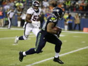 Seattle Seahawks running back Thomas Rawls, right, runs past Denver Broncos outside linebacker Corey Nelson, left, for a touchdown after catching a pass during the second half of a preseason NFL football game, Friday, Aug. 14, 2015, in Seattle.