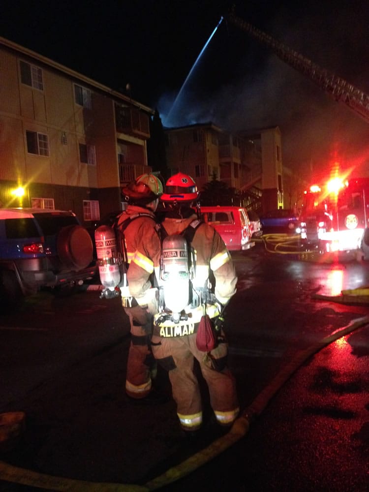 Firefighters consult as they work to contain a fire at the Bridge Creek Apartments today.