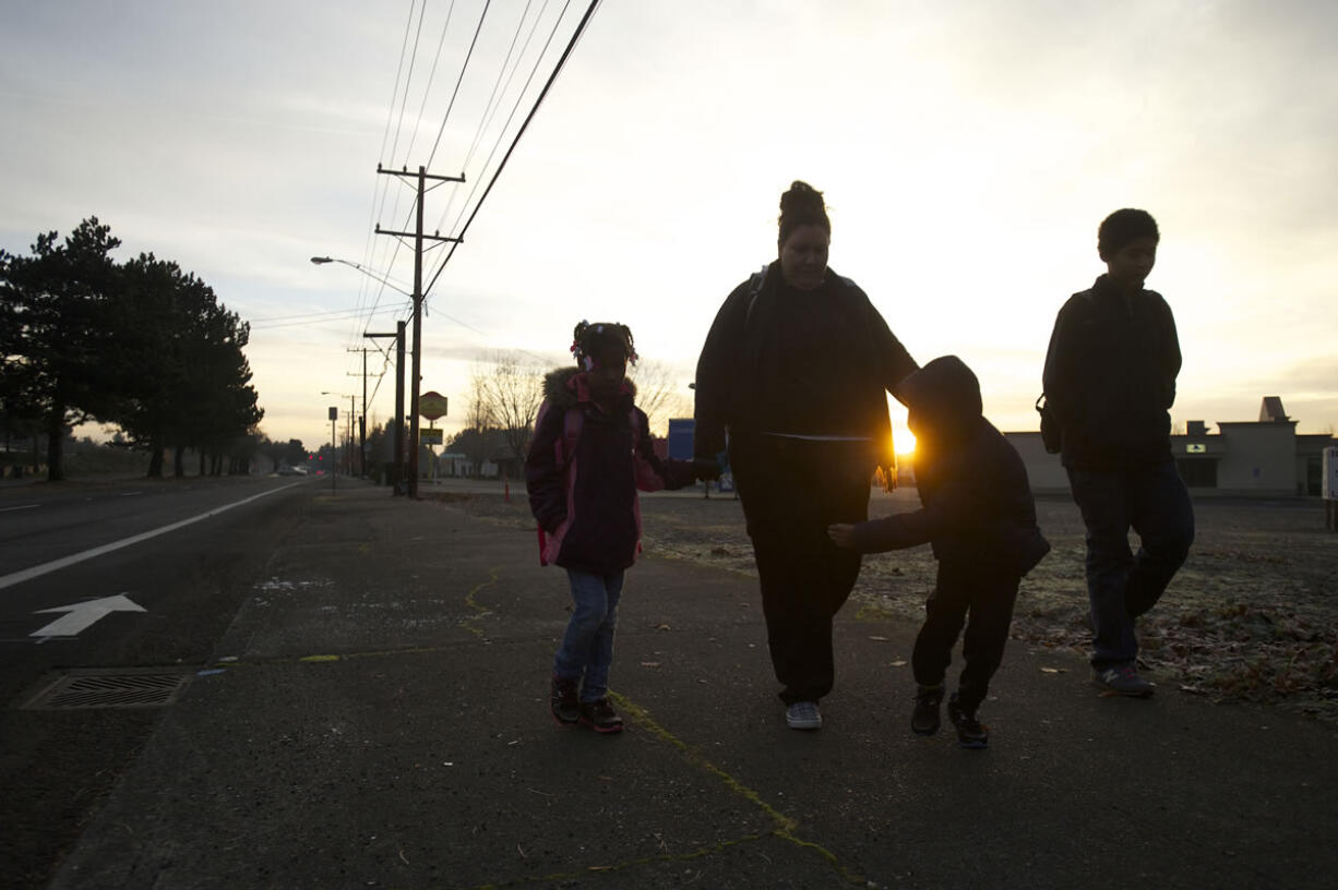 Jessica Richey, second from left, and her children, Saakkaaya, 7, left; Ezekiel, 7, second from right; and Isaac, 12, make the early-morning trek to school.