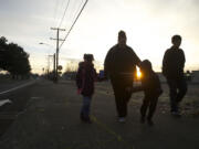 Jessica Richey, second from left, and her children, Saakkaaya, 7, left; Ezekiel, 7, second from right; and Isaac, 12, make the early-morning trek to school.