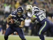 Seattle Seahawks' defensive end Michael Bennett returns a fumble for a touchdown against the New Orleans Saints in the first half of an NFL football game, Monday, Dec. 2, 2013, in Seattle.