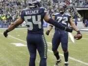 Seattle Seahawks defensive end Michael Bennett, right, celebrates after recovering a fumble, with middle linebacker Bobby Wagner during the first half of an NFC divisional playoff NFL football game against the New Orleans Saints in Seattle, Saturday, Jan. 11, 2014.