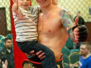 Austin Springer of Vancouver, holding son Jaxson, 3, after winning the first Main Event Sports Productions professional mixed martial arts championship on Saturday at the Red Lion Inn at the Quay.