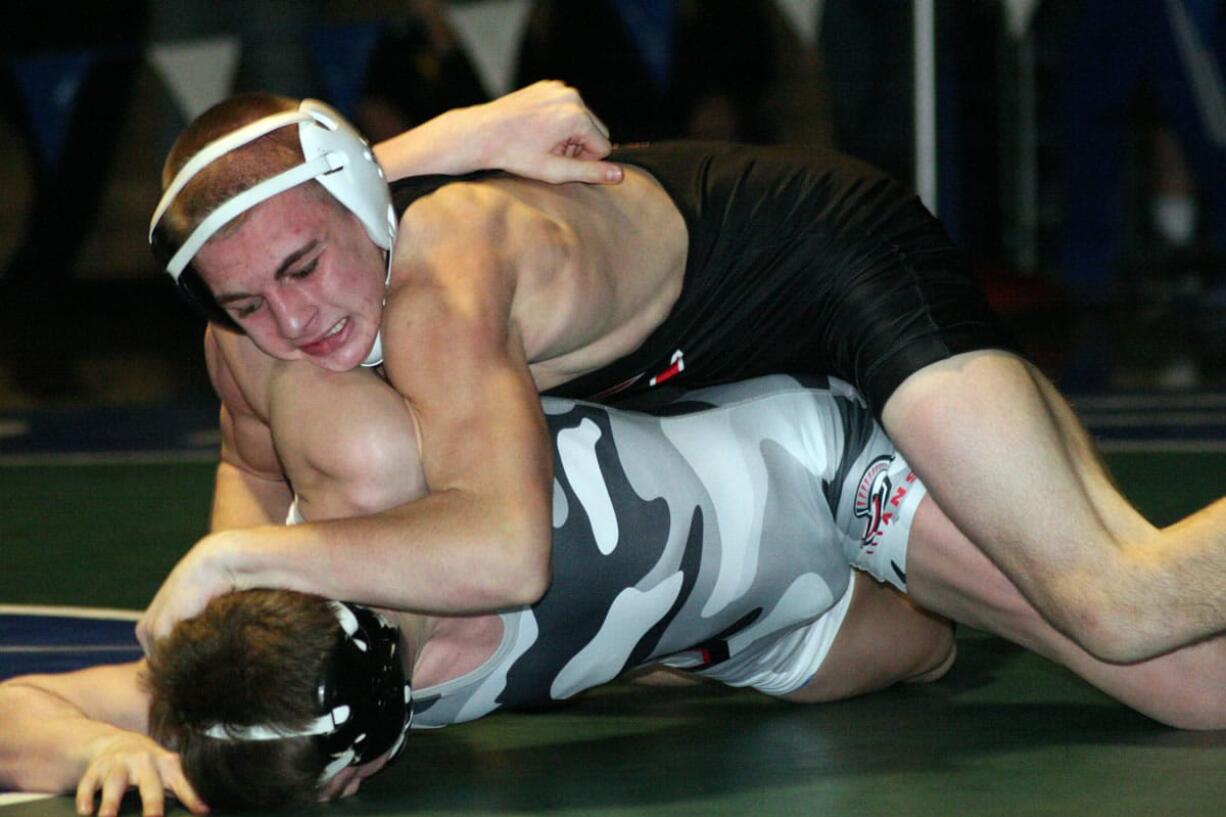 Bryant Elliott buries Daniel Rice's head into the mat during the 132-pound Clark County championship match Saturday, at Mountain View High School. The Camas Papermaker beat the Union Titan 15-11.