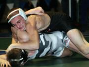 Bryant Elliott buries Daniel Rice's head into the mat during the 132-pound Clark County championship match Saturday, at Mountain View High School. The Camas Papermaker beat the Union Titan 15-11.