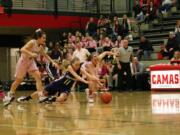 Meghan Finley (right) lunges for the basketball Friday, at Camas High School. The Papermakers beat the Heritage Timberwolves 62-20.