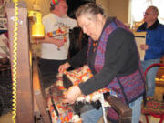 Barbara Quinn, assisted by Dick Lindstrom, weaves a rug on a counter balance loom at the Two Rivers Heritage Museum in Washougal using selvage materials from Pendleton Woolen Mills.