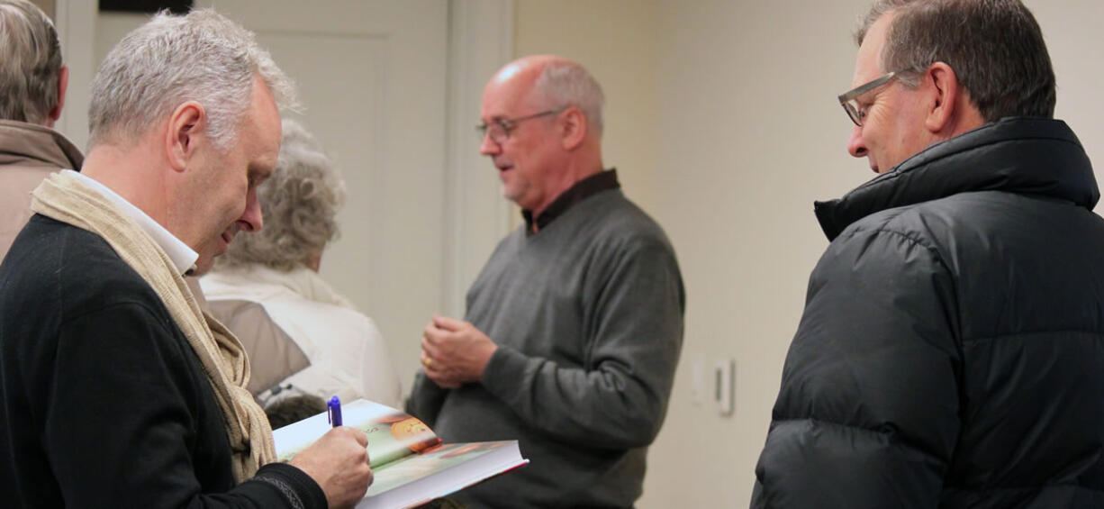 &quot;The Burma Cookbook&quot; authors Morrison Polkinghorne (left) and Robert Carmack (center) sign copies of their book and talk with friends and other community members who turned out for their presentation at the Camas Public Library on Wednesday.