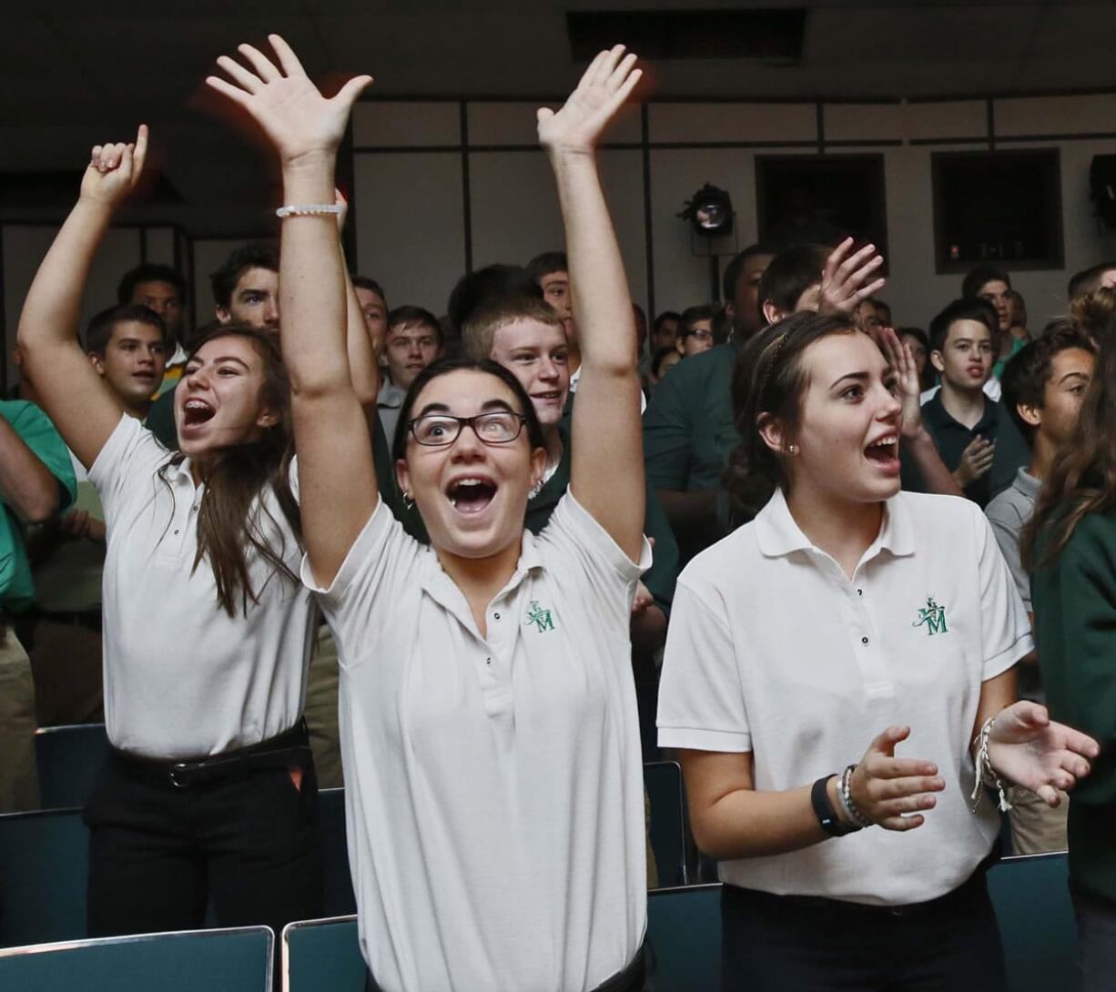 Gwen Bruderly, from left, Olivia Conti and Jordan Keathley, all freshmen at St. Vincent-St. Mary High School in Akron, Ohio, cheer as members of The Takeover, a ministry group with the nonprofit Generation Akron, presents a Hope Assemblies at the school in September.