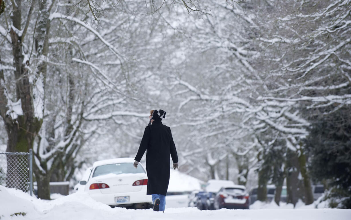 Dee Clingan walks along Northwest 43rd Street on an icy Sunday in Vancouver.