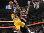 Denver Nuggets forward J.J. Hickson, left, has his shot blocked by Portland Trail Blazers center Robin Lopez in the third quarter of Portland's 113-98 victory in an NBA basketball game in Denver, Friday, Nov. 1, 2013.