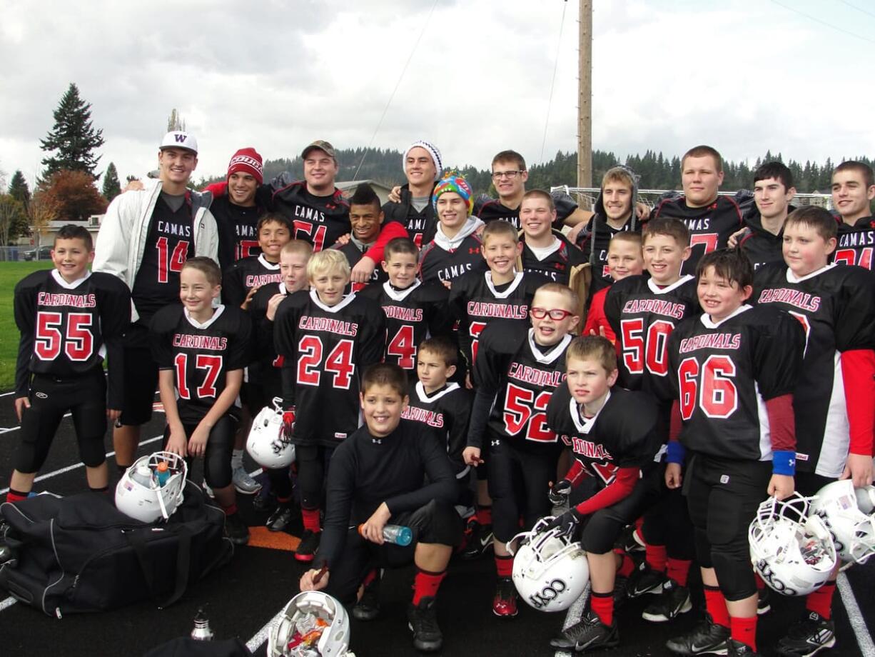 Fourteen Camas High School football players surprised the fourth- and fifth-grade CCYF Camas Cardinals by showing up at their playoff game Saturday, at Fishback Stadium.