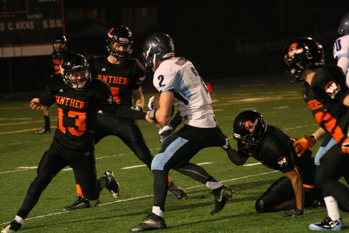 Donald Holbert clings to a Hockinson Hawk before Brandon Casteel and Luke Hiersche join the fray Friday, at Fishback Stadium.