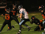 Donald Holbert clings to a Hockinson Hawk before Brandon Casteel and Luke Hiersche join the fray Friday, at Fishback Stadium.