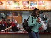 Dalia Aguilera, left, and Alejandro Velasquez prepare orders for customers at Wendy's in Burbank, Calif.,  in September. In January, Wendy's 99-cent bargain menu transformed into Right Price Right Size and includes items costing as much as $2.