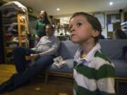 Gabriel Ruthford fixes his gaze on the television as he watches his favorite documentary about trains at his home in Maple Valley.