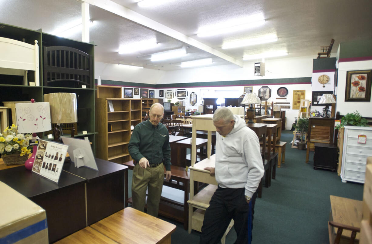 Vancouver Woodworks Furniture owner Bruce Lyons, left, helps customer Malcolm Storey of Vancouver look for bedroom furniture Oct.