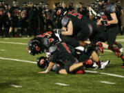 The Papermakers bury a Monroe Bearcat on Doc Harris Stadium turf Friday.