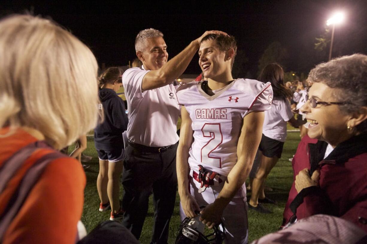 Coach Jon Eagle congratulates his son Zach after a win against Canby earlier this season.