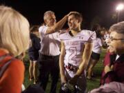 Coach Jon Eagle congratulates his son Zach after a win against Canby earlier this season.