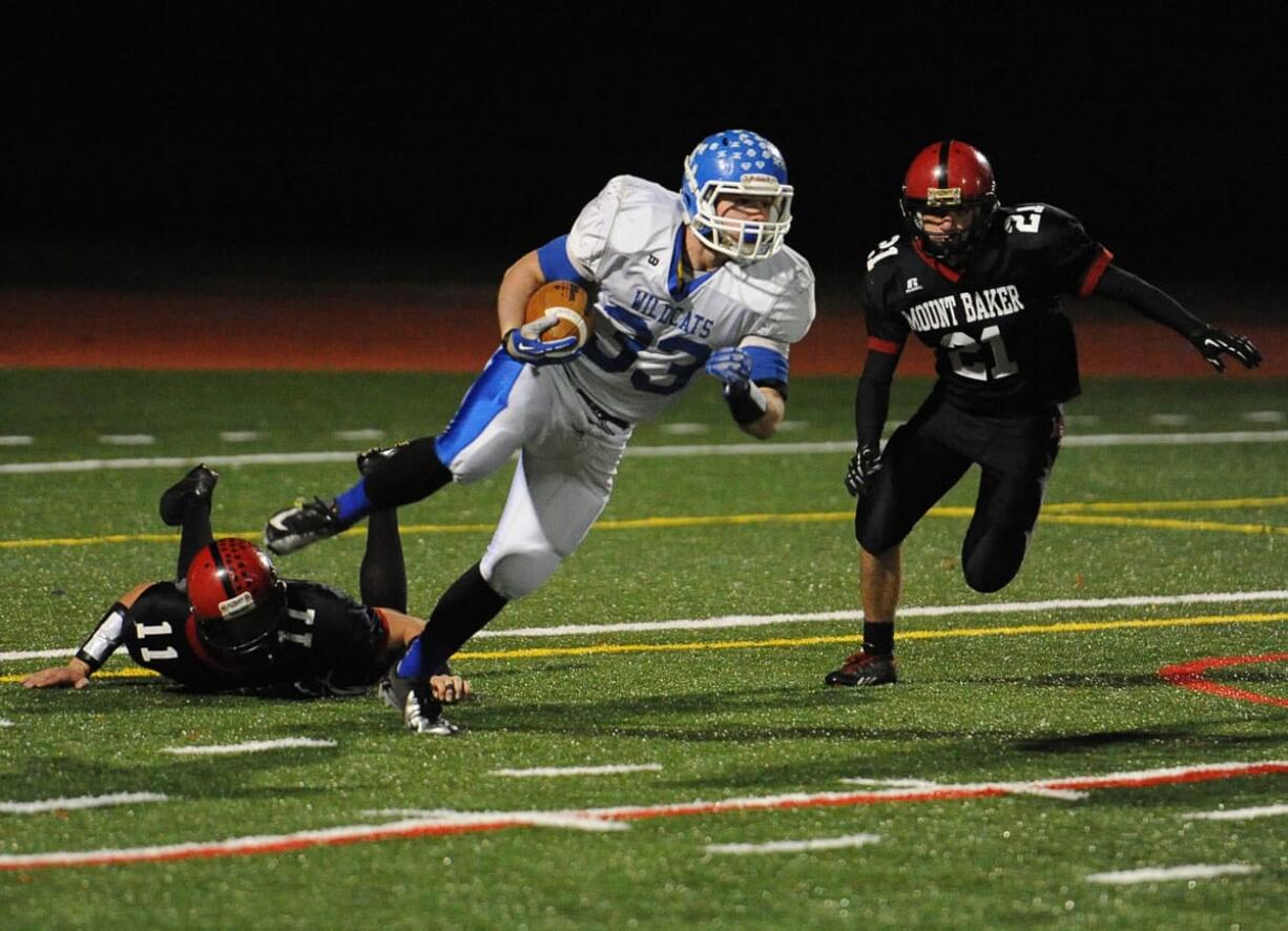 La Center High School's Conner Fulton attempts to break free with Mount Baker's Joey Walton closing in during the state football quarterfinals, Saturday, Nov. 23, 2013, at Civic Field in Bellingham.