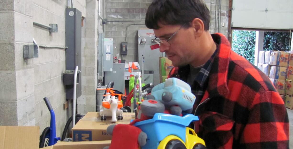 Mark Lockwood, a volunteer, sorts through toy donations in a warehouse at River Rock Church, in Camas. The items, as well as clothing and shoes for men, women and children, will soon be sent to people affected by Typhoon Haiyan, in the Philippines. Donations of bedding, hand sanitizer, bandages, diapers, school supplies, pots, pans and tarps, are accepted at River Rock through Saturday, Dec. 7. &quot;The storm was an act of nature,&quot; said Tony Williamson, a pastor.