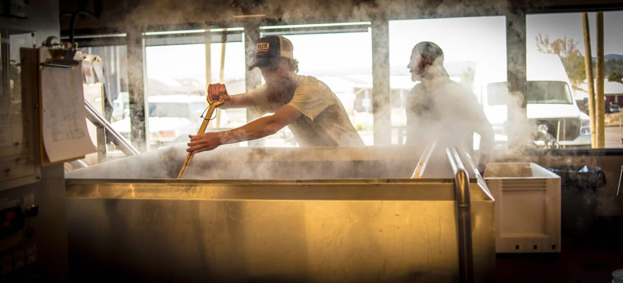 Employees at Crux Fermentation stir hops at Crux&#039;s factory in Bend, Ore.