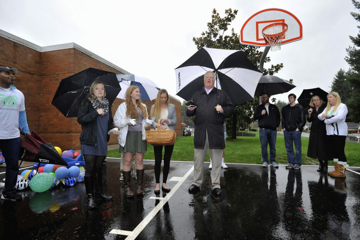 David Long, center, speaks on the basketball court dedicated Tuesday in memory of his daughter-in-law, Tiffany Long, pictured at top. She was a classroom aide at the 49th Street Academy and was working to become a special-education teacher.