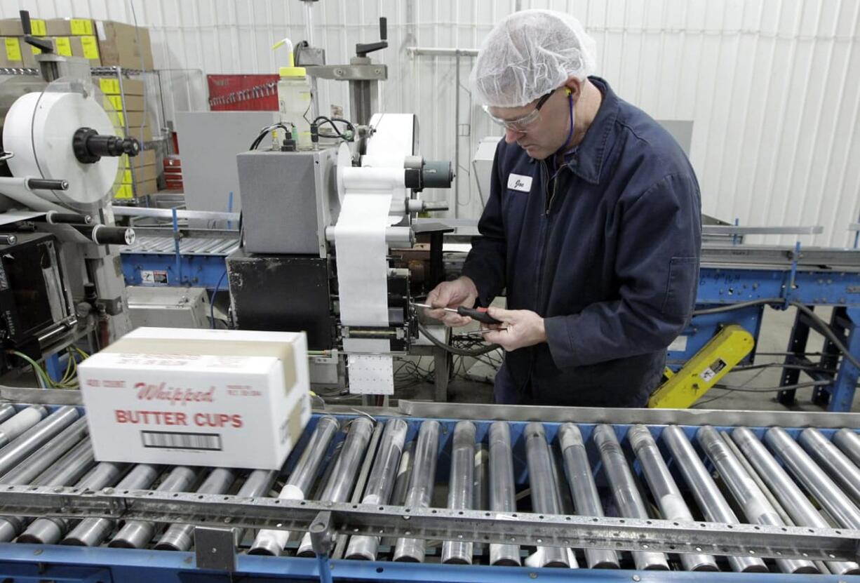 Mark Hoffman/Milwaukee Journal Sentinel
Joe Ortner maintains a robotic palletizer Nov. 21 at Grassland Dairy Products Inc. in Greenwood, Wis.