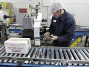 Mark Hoffman/Milwaukee Journal Sentinel
Joe Ortner maintains a robotic palletizer Nov. 21 at Grassland Dairy Products Inc. in Greenwood, Wis.