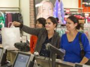 Harinder Kaur, center, and her sister Rupinder Kaur, right, shop at the Folsom Premium Outlets in Folsom, Calif., on Nov.