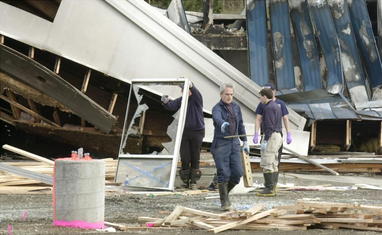 Officials work at the scene in the aftermath of a fire at the former Desire Video in 2003.