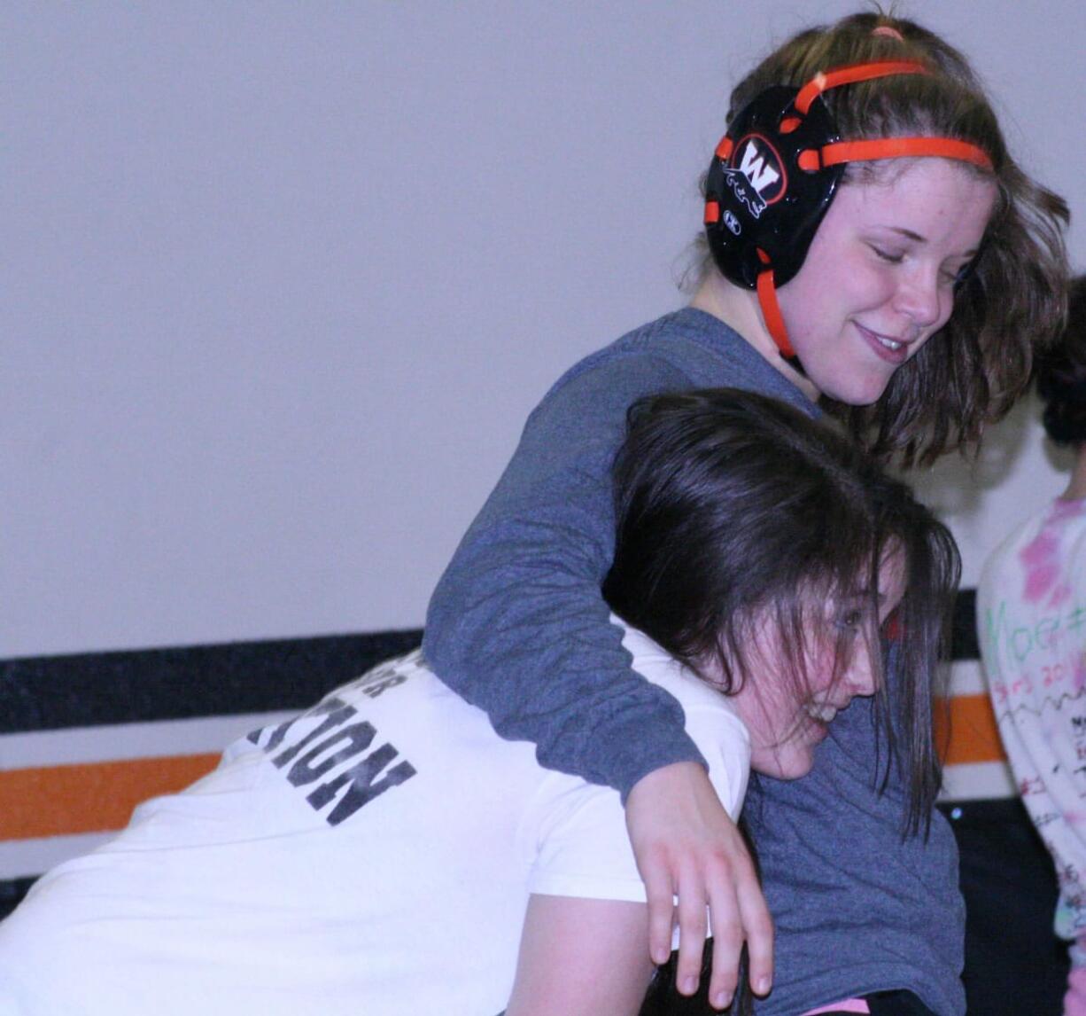 Erin Locke hugs teammate Christina Murray after a tussle in the jungle Thursday, at Washougal High School.