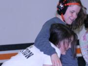 Erin Locke hugs teammate Christina Murray after a tussle in the jungle Thursday, at Washougal High School.