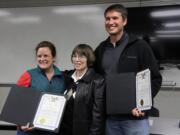 Karen Burbank, 39, left, and husband Rhett, 40, hold the lifesaving awards they were presented Tuesday for coming to the aid of their neighbor Sharon Miller, 65, center.