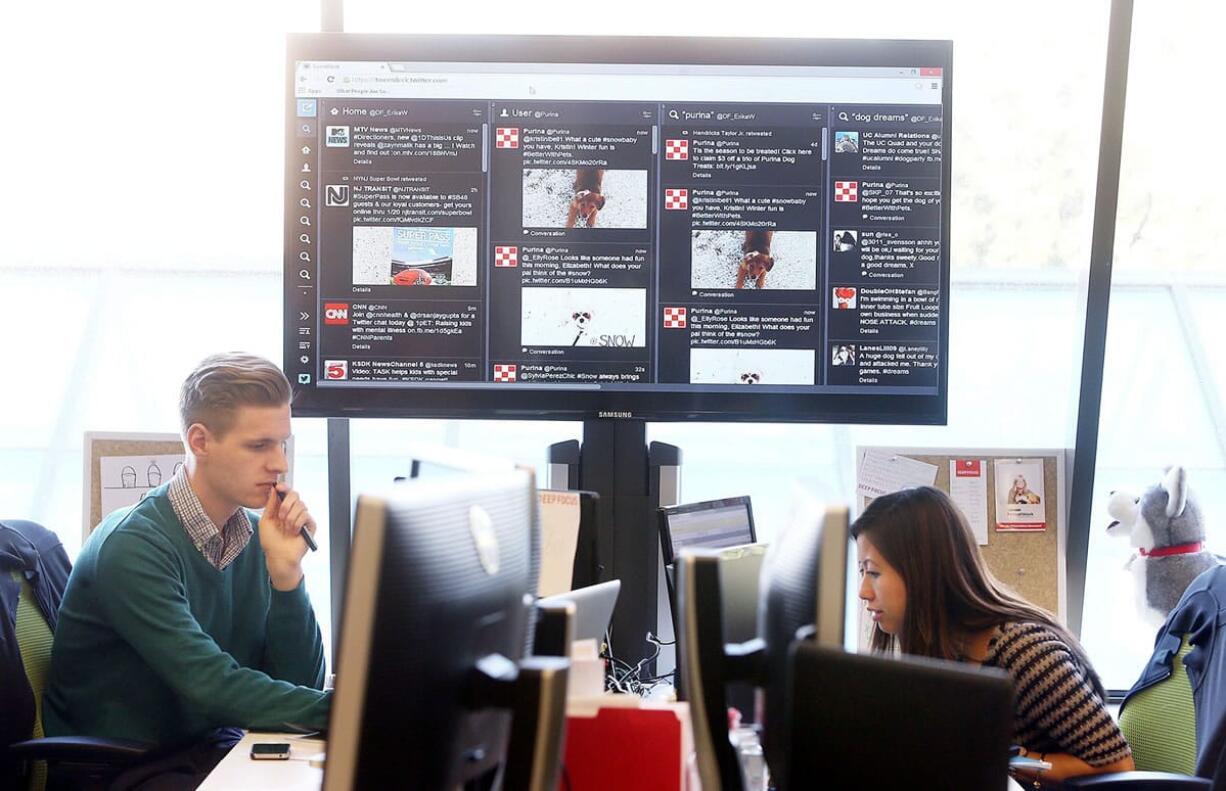 Associate manager of social media communications Rex Oberle, left, with Nestle Purina Pet Care's social media effort The Feed, and senior manager of social media communications Patricia Lee monitor Twitter on Dec. 11 in St.