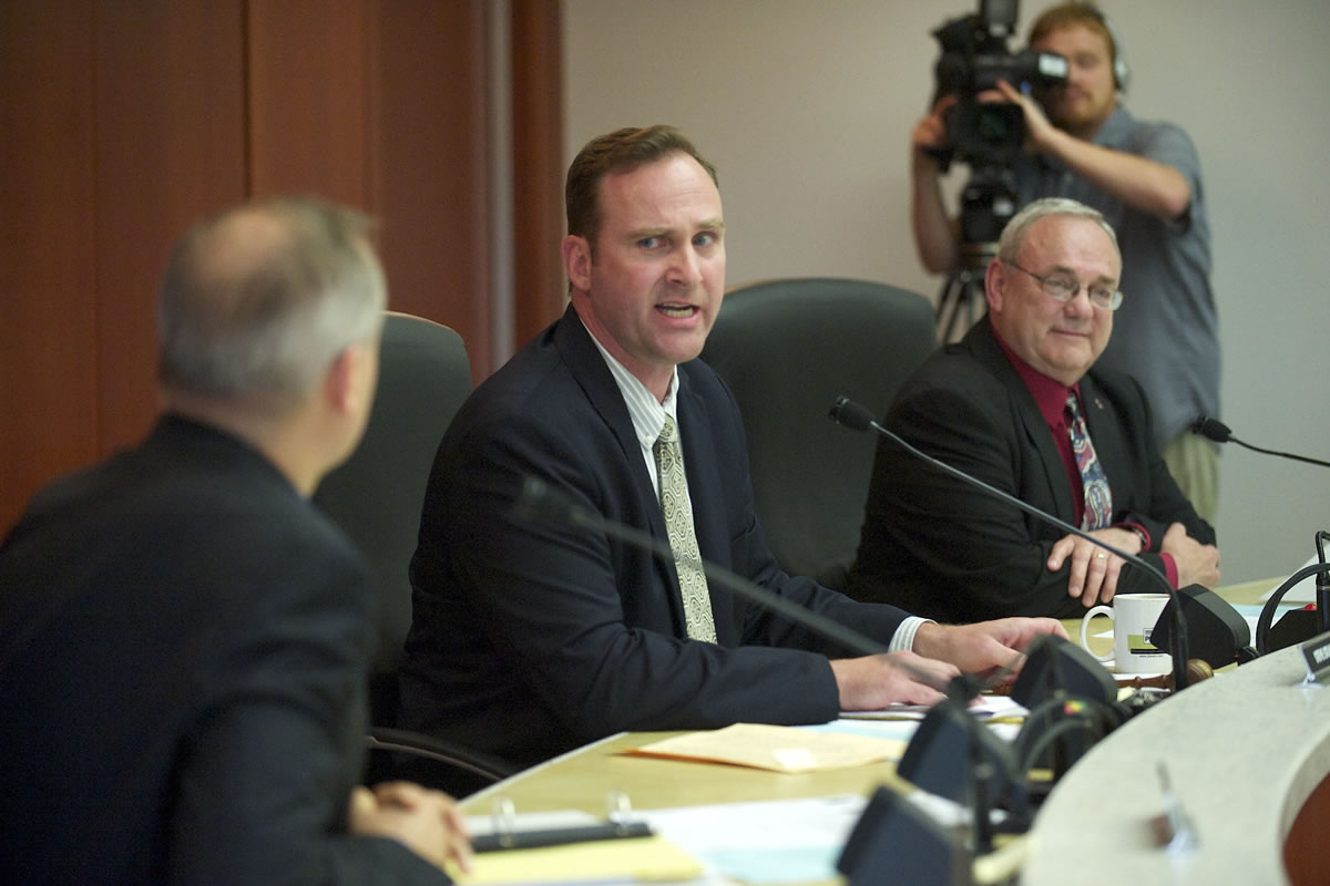 Clark County Commissioner Steve Stuart, center, looks to David Madore, left, announcing his plan to file an ethics complaint during a commissioners meeting in May.