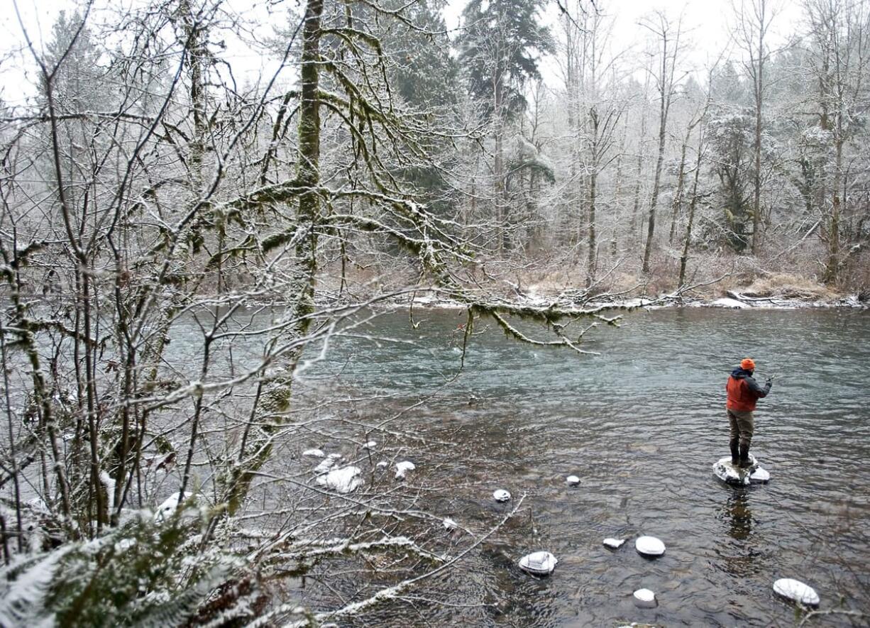 Battle Ground resident Jason Martinez stands on a rock while fishing for winter steelhead at Lewisville Park on Tuesday.