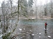 Battle Ground resident Jason Martinez stands on a rock while fishing for winter steelhead at Lewisville Park on Tuesday.