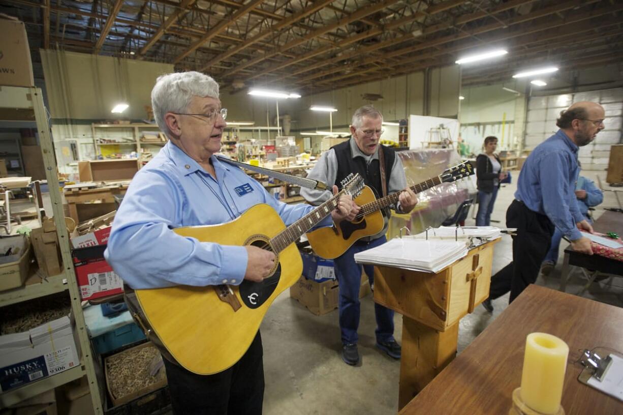 The Rev. Duane Sich, left, founder and longtime leader of homeless ministry Friends of the Carpenter, leads a musical prayer service on his 12-string guitar.