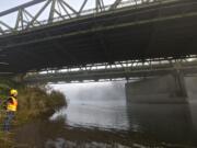 The Washington State Department of Transportation's Abbi Russell looks up Friday at the North Fork Lewis River Bridge in Woodland.