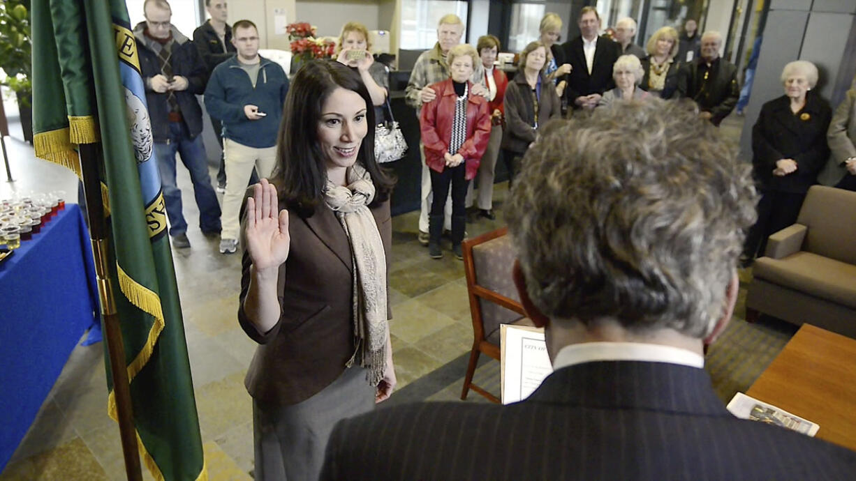 Stephen Horenstein, right, swears Alishia Topper, left, in as a new member of the Vancouver City Council Tuesday December 31, 2013 in Vancouver, Washington.