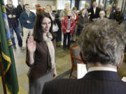 Stephen Horenstein, right, swears Alishia Topper, left, in as a new member of the Vancouver City Council Tuesday December 31, 2013 in Vancouver, Washington.