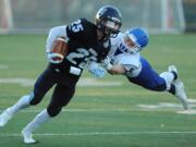 Hockinson's Matt Henry (25) fights to elude the grasp of Sedro-Woolley's Spencer Hoover.