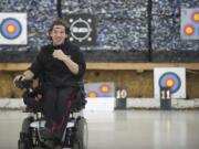 Chris Cash, who uses a wheelchair due to cerebral palsy, heads to the firing line after setting his target at Archery World, where he volunteers regularly.