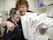 Shelli Fanning, left, shares a hug with supervisor Vera Babiy on Fanning's last day of work at the Red Lion Hotel Vancouver at the Quay. Fanning has Down syndrome but family and professional support helped her succeed at her housekeeping job for 23 years.