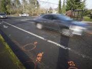 Cars drive over markings spray-painted by traffic investigators at the site of Sunday night's fatal hit-and-run collision, Northeast 72nd Avenue and Northeast Vancouver Mall Drive, where two women were killed.